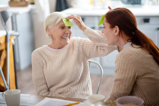 istock Red-haired caregiver joking and having fun with aged lady 1177288128