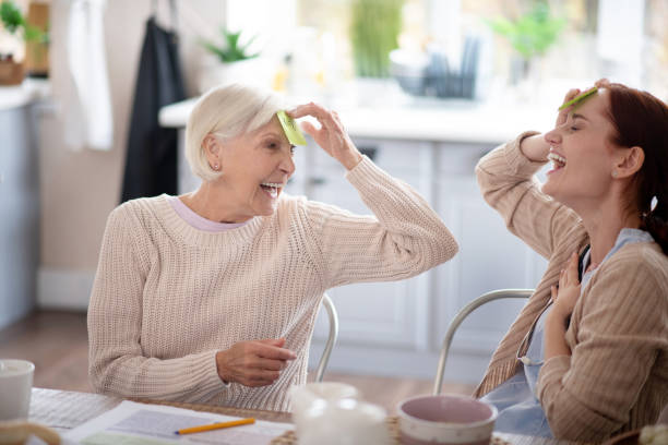 istock Laughing pensioner playing words game with nurse 1177288135