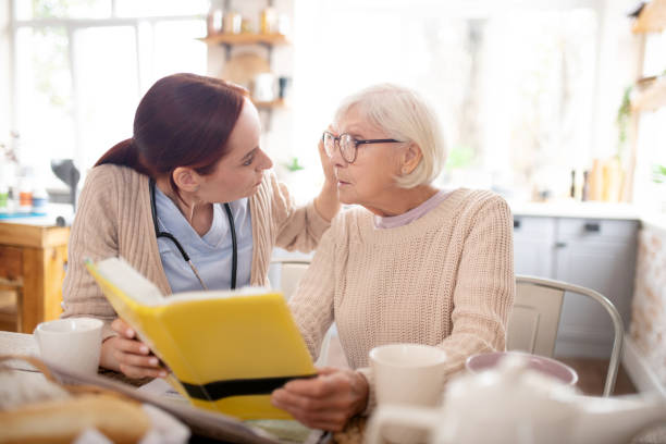 istock Caring red-haired nurse fixing glasses for retired woman 1177288241