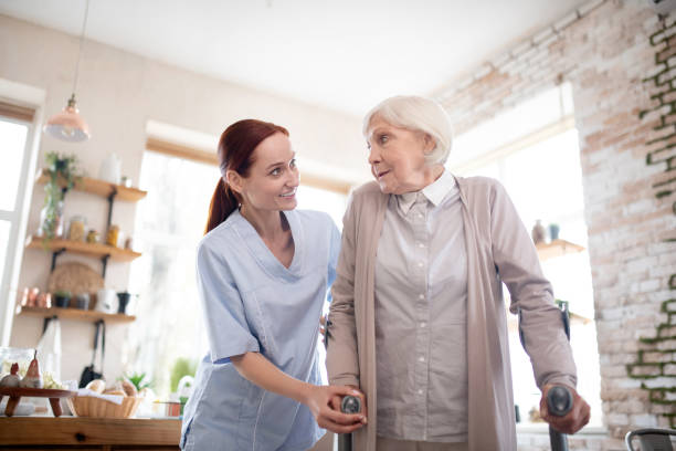 istock Red-haired caregiver supporting woman with crutches 1177288254