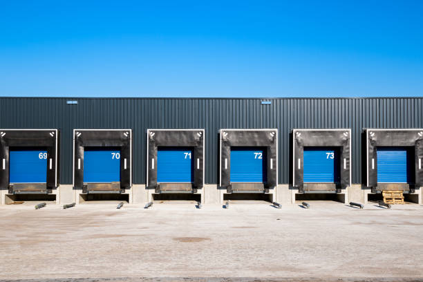 Warehouse loading docks Row of loading docks with shutter doors at an industrial warehouse. bay of water stock pictures, royalty-free photos & images