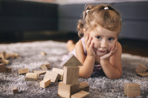 Cute baby girl playing with wooden blocks stock photo