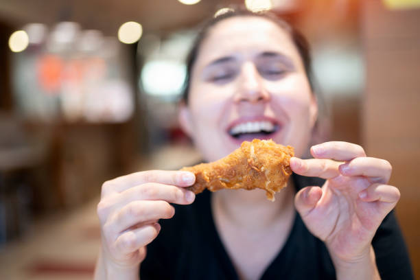 istock Young woman with fried chicken 1177290329