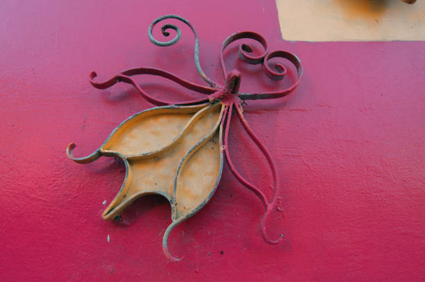 A closeup shot of a vintage iron figure on the wall next to the window.