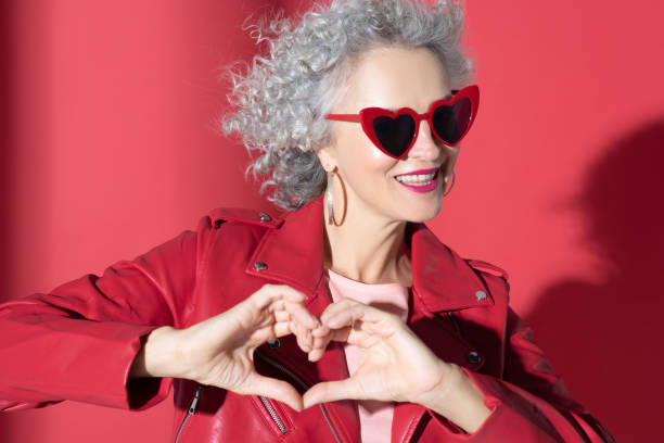istock Woman in red sunglasses and jacket smiling broadly 1177292957