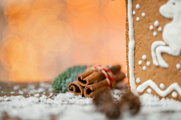 Cinnamon and christmas decoration on wooden table. Spruce branch, orange and snow. Morning in the bright living room. Holiday mood.