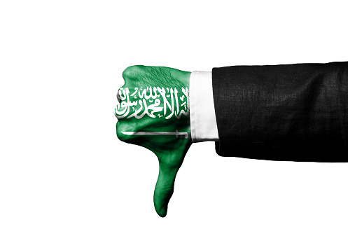 Businessman showing THUMBS DOWN hand sign with SAUDI ARABIA FLAG over hand / Flag concept (Click for more)