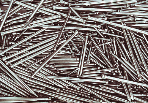 Metal nails close up, isolated industrial seamless background.