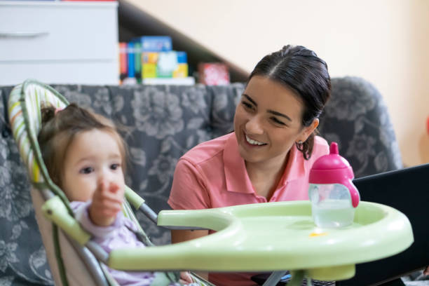 istock Mother  sitting on a sofa and working on a laptop 1177303133