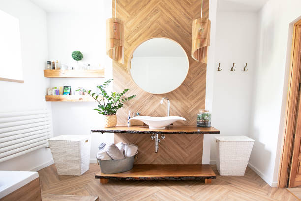 Boho style bathroom interior. White sink on wood counter with a round mirror hanging above it. Bathroom interior. Bohemian Bathroom stock pictures, royalty-free photos & images