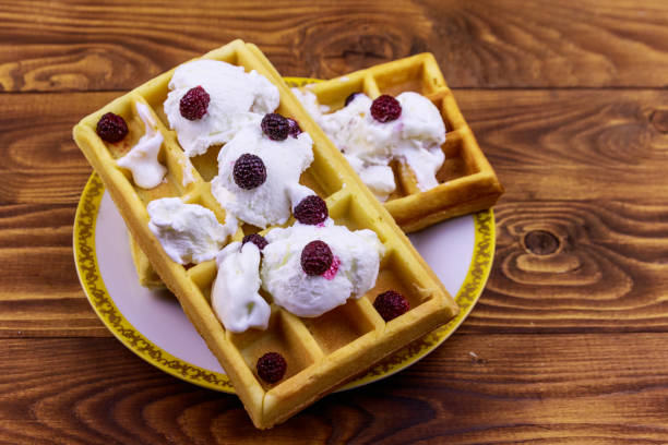 istock Belgian waffles with ice cream and blackberries on wooden table 1177307551