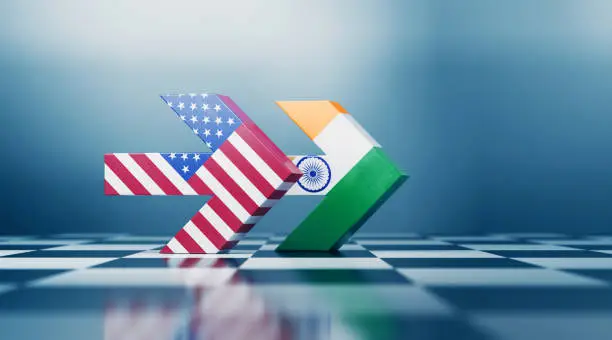 Two arrows textured with American and  Indian flags pointing the same direction on black and white chessboard. Politics and strategic partnership concept. Horizontal composition with selective focus and copy space.