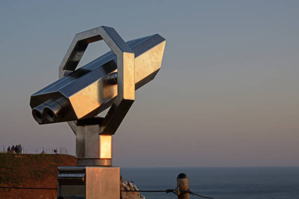 Photo of Public telescope to watch the birds at a vantage point on the cliffs of Heligoland during sunset, copy space