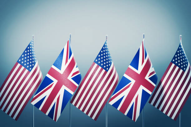 American and British flags in a row on grey background. Horizontal composition with copy space and selective focus. Great use for American and British politics.