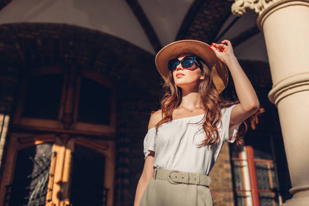 Fashion model. Outdoor portrait of tourist woman enjoying sightseeing in Lviv. Girl looking at ancient atchitecture Fashion model. Outdoor portrait of young tourist woman enjoying sightseeing in Lviv. Girl looking at ancient atchitecture at sunset white shirt black skirt stock pictures, royalty-free photos & images