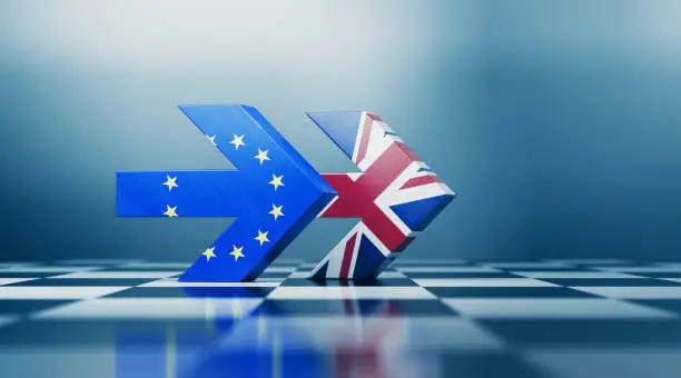 Two arrows textured with British and European Union flags pointing the same direction on black and white chessboard. Politics and strategic partnership concept. Horizontal composition with selective focus and copy space.