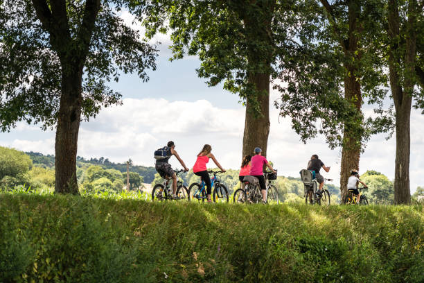 A group of cyclists ride along a canal in Brittany, France stock photo