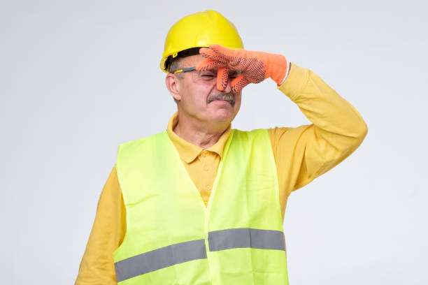 road worker closes nose because of unpleasant smell stock photo
