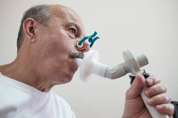 senior hispanic man man testing breathing function by spirometry - physical checkup imagens e fotografias de stock