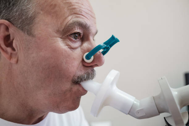 senior hispanic man man testing breathing function by spirometry - physical checkup imagens e fotografias de stock