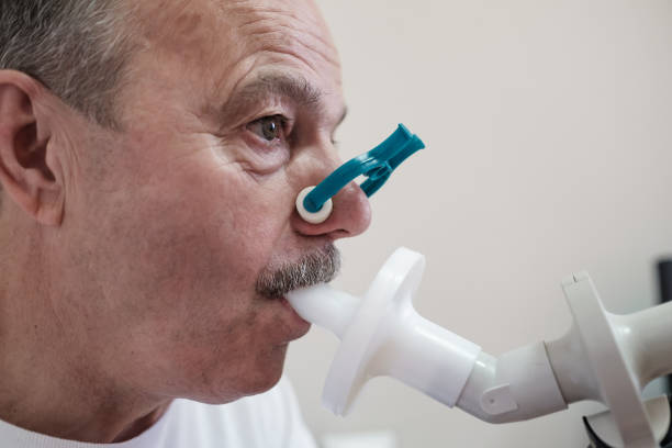 старший испаноязычный человек, проверяя функцию дыхания по спирометрии - physical checkup стоковые фото и изображения