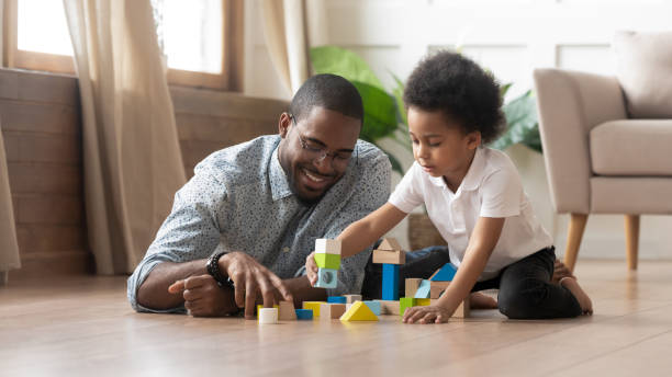 istock African father and son play with toy blocks on floor 1177320053