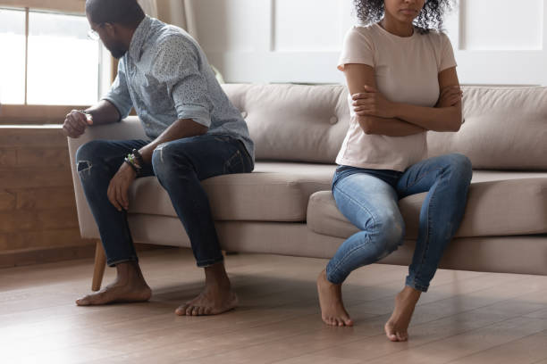istock Spouses sitting on couch separate from each other after quarrel 1177320109