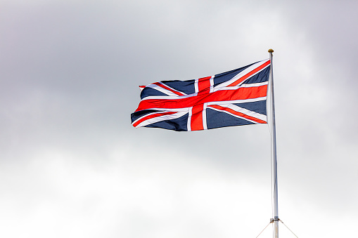 British Flag Union Jack against dark clouds