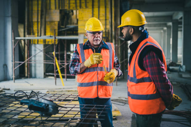 istock Mature construction worker talking to young colleague 1177326231