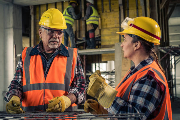 istock Mature male construction worker talking to female construction worker 1177326232