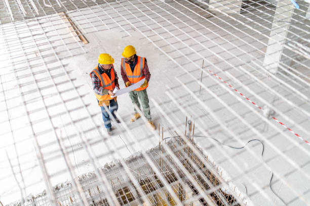 istock High angle view of construction workers examining blueprints at a construction site 1177326280
