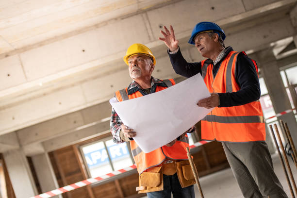 istock Investor talking to construction foreman while holding a blueprint and pointing into the distance 1177326293