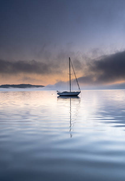 istock Misty Morning Sunrise Waterscape with one Boat 1177326349