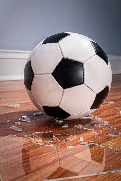 istock A soccer ball with broken glass from a window on the floor 1177333020