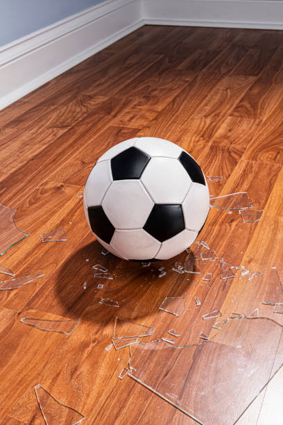 istock A soccer ball with broken glass from a window on the floor 1177333037