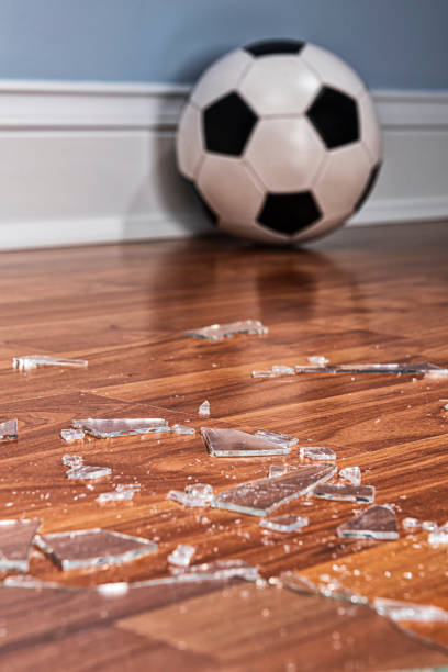 istock Broken glass from a window pane on the floor with soccer ball 1177333070