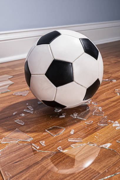 istock A soccer ball with broken glass from a window on the floor 1177333078
