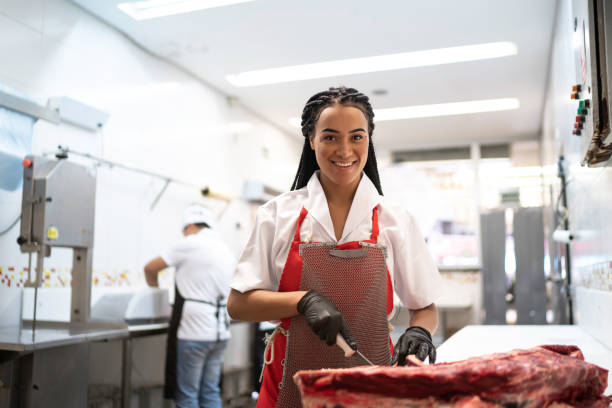 Portrait Of A Female Butcher Cutting A Piece Of Meat In Butchers Shop Stock  Photo - Download Image Now - iStock