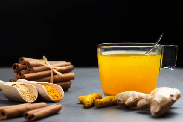 herbal ginger and turmeric tea in glass cup with ginger root, dry turmeric, cinnamon sticks and their powder - ginger tea cup cold and flu tea imagens e fotografias de stock