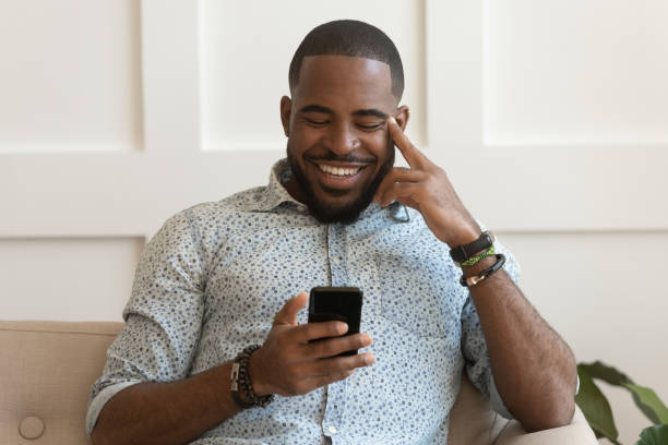 istock Happy smiling young african american guy holding cell phone. 1177334831