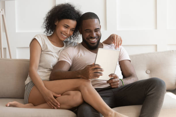 istock Smiling happy african american family spouse using digital tablet. 1177334883