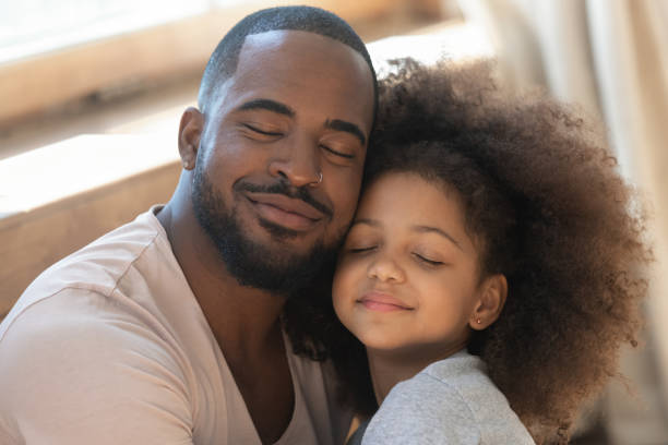 istock Close up head shot young black man embracing little daughter. 1177334892
