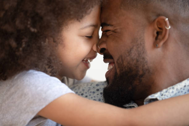 istock Happy caring african american man touching foreheads with smiling daughter. 1177334896