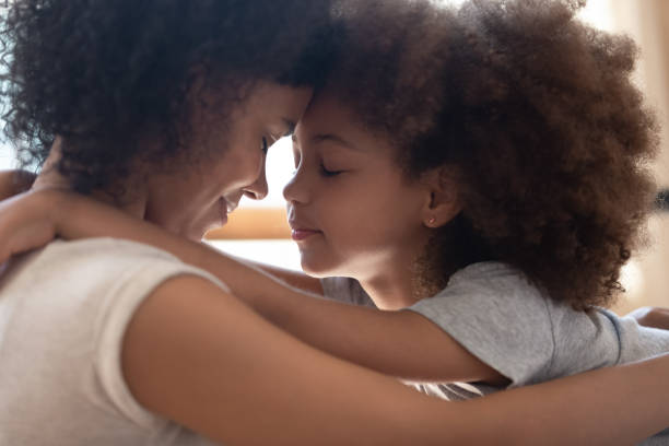 madre raza mixta tocando frentes con una hija linda. - family american culture black child fotografías e imágenes de stock