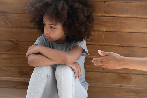 Upset african american little adorable kid girl ignoring lent mommys hand. Offended unhappy mixed race child suffering from quarrel, does not want to forgive, feeling stressed and misunderstood.