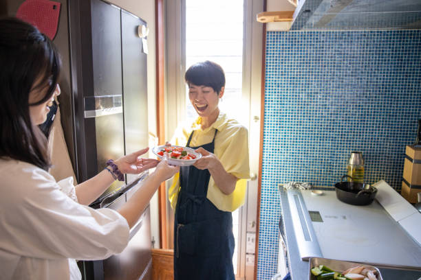 istock Female friends serving salad in the kitchen 1177335269
