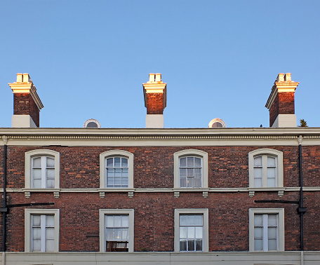 windows and chimneys on a row of elegant brick 18th century english houses in chester