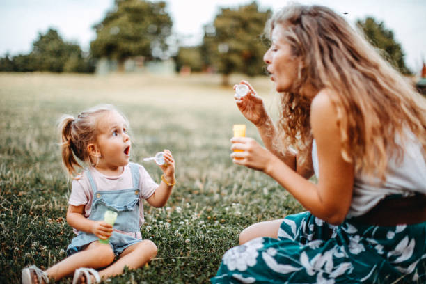 istock Mother and daughter playing with bubble soap in nature 1177339721