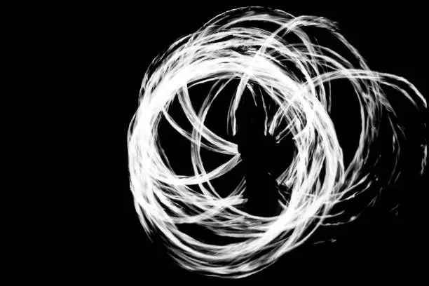 Long exposure of fire-dance performance in black and white