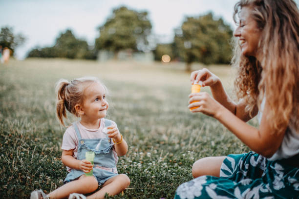 istock Mother and daughter playing with bubble soap in nature 1177340742